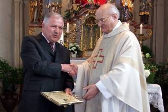 Bürgermeister Franz Schneider überreicht die Ernennungsurkunde an den Jubilar Pfarrer Leonhard Schinner (zum Vergrößern anklicken)